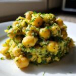 A close-up serving of Lemony Chickpea Salad with Herbs, featuring whole chickpeas coated in a bright green, herby dressing.