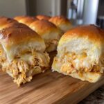 Close-up of two halves of Mini BBQ Chicken Sliders showing shredded chicken and melted cheese inside soft rolls.