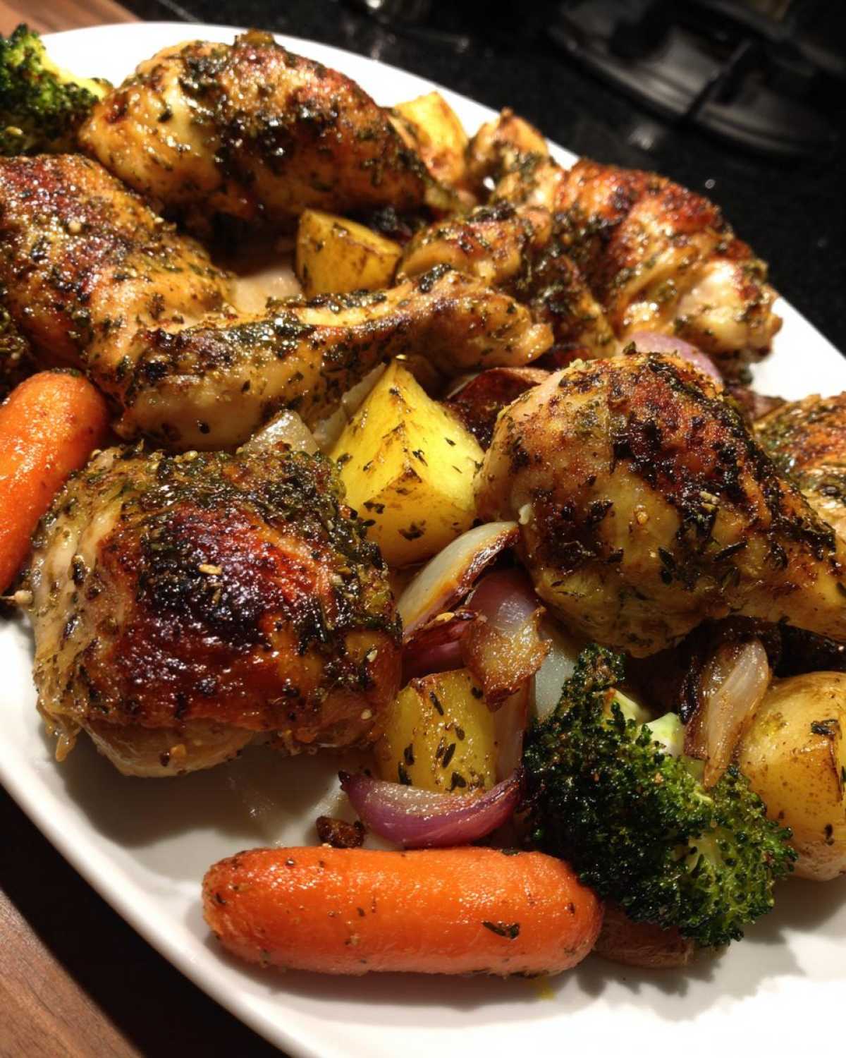 Close-up of Sheet Pan Lemon Herb Roasted Chicken Pieces and Veggies on a white platter.