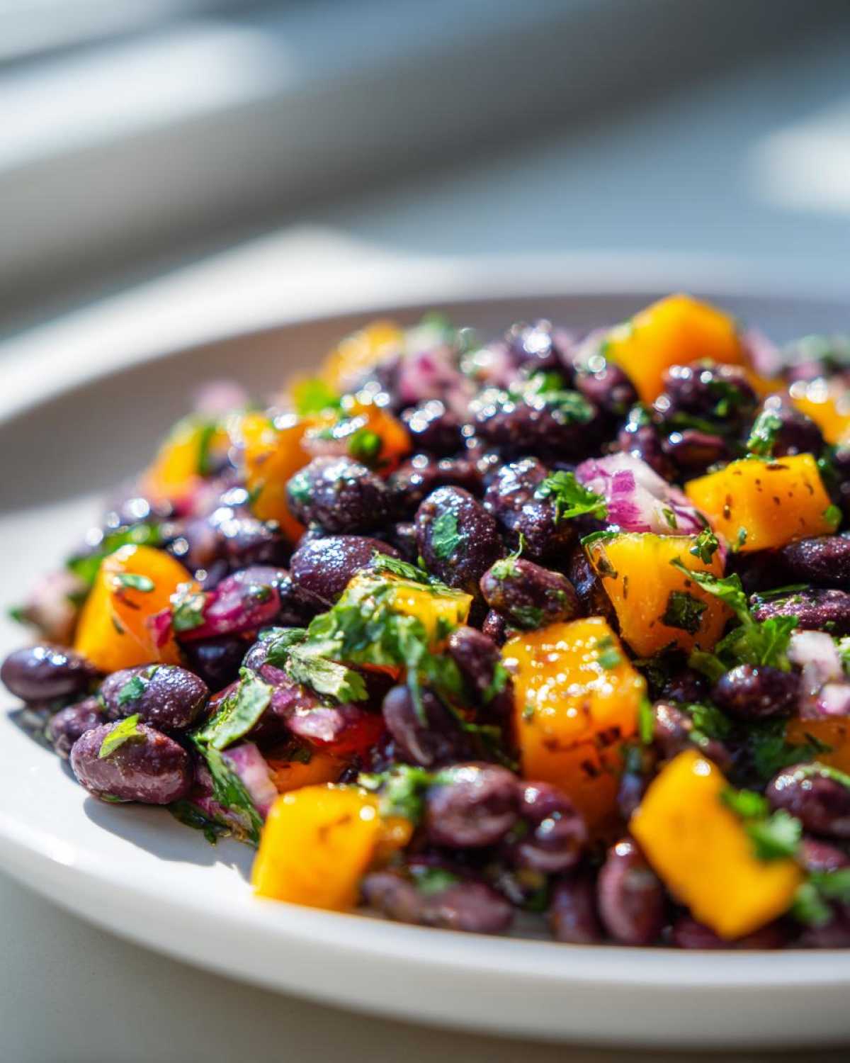 Close-up of Vibrant Black Bean and Mango Salad with diced mango, red onion, and cilantro.